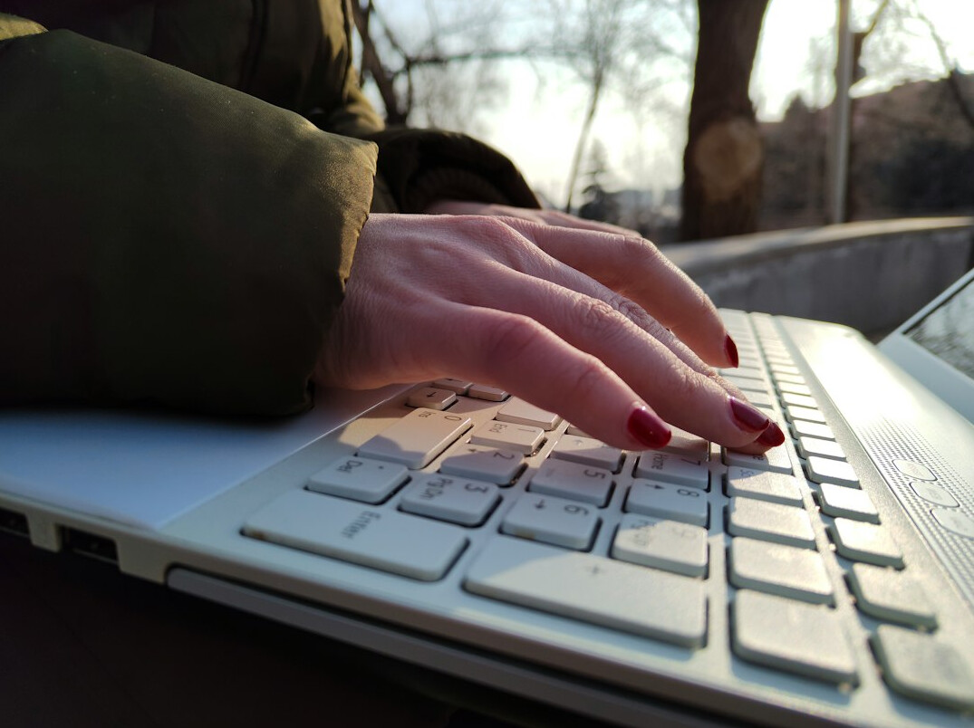 mystery writer typing on laptop